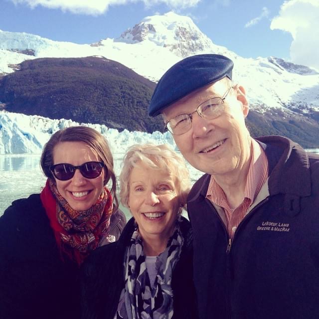 Jim, his wife Marianne, and their daughter smile in front of a snowy mountain peak.